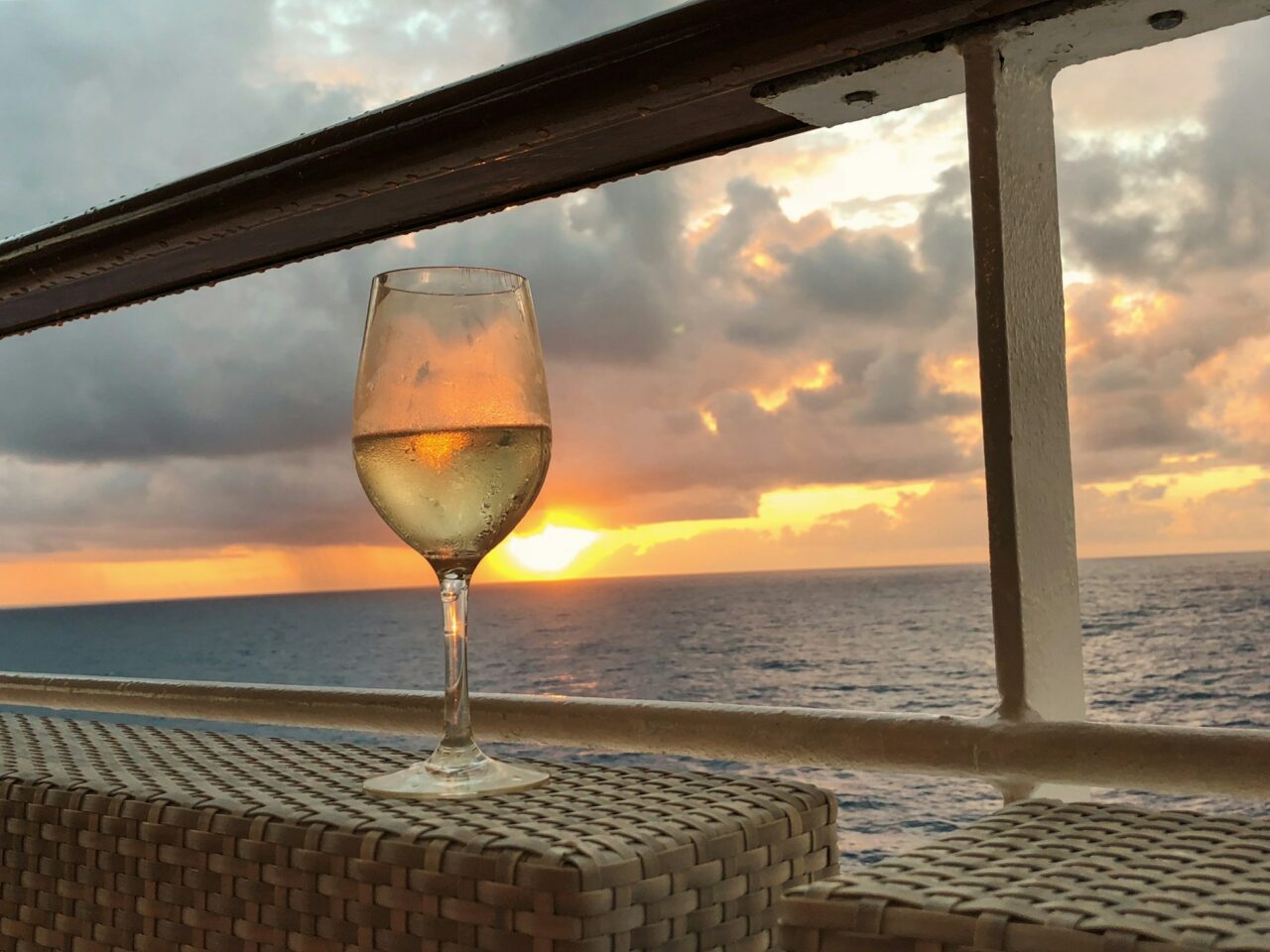 copo de vinho ao por do sol com vista para o mar num navio, Dicas para fazer um cruzeiro