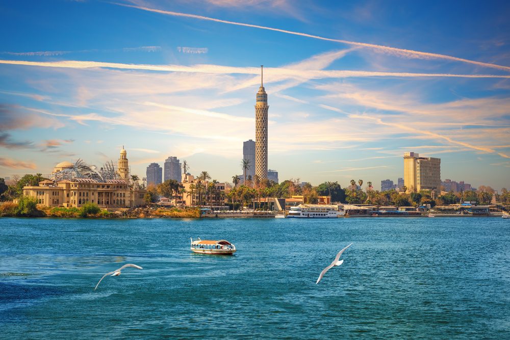 Paisagem do Rio Nilo com barcos e cidade ao fundo