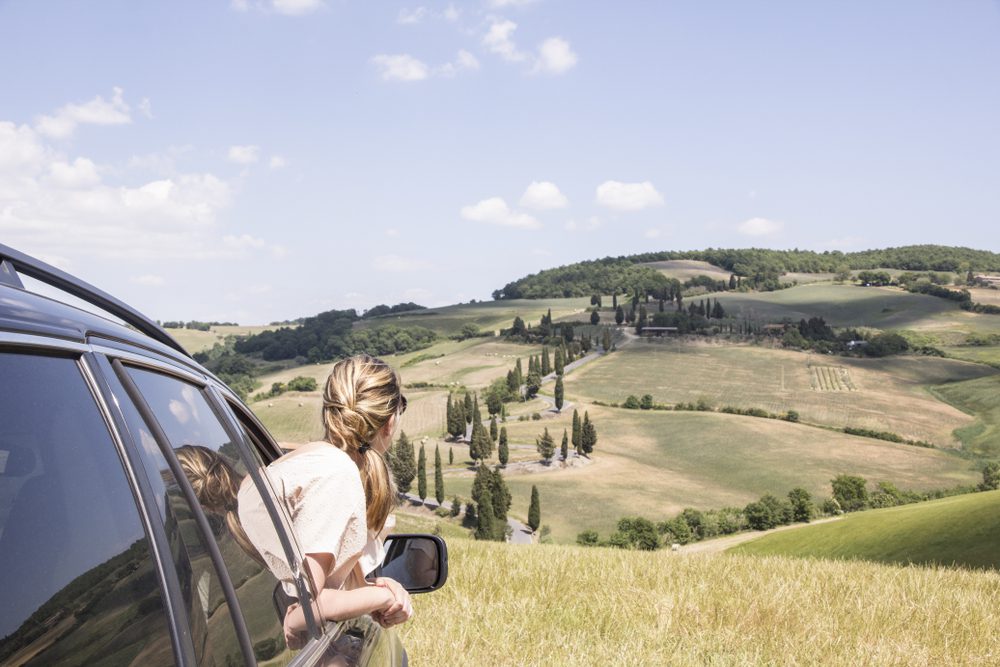 Mulher dentro de um carro, numa roatrip na Toscana, em Itália, melhores destinos para uma viagem de mãe e filha