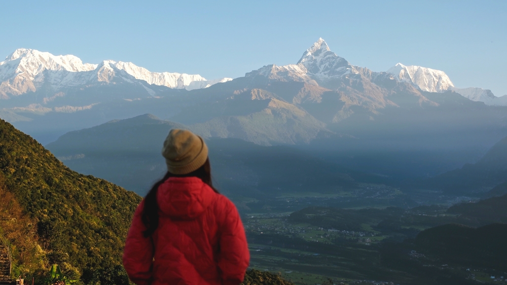 Mulher viajando no pico Machapuchare, serra de Annapurna / Farknot Architect / Shutterstock